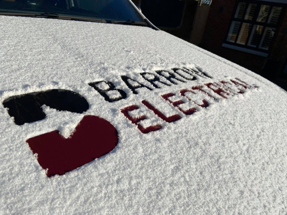 This image shows a car covered in snow, the Barrow Electrical Logo has not been snowed on, so it is showing in between the snow.