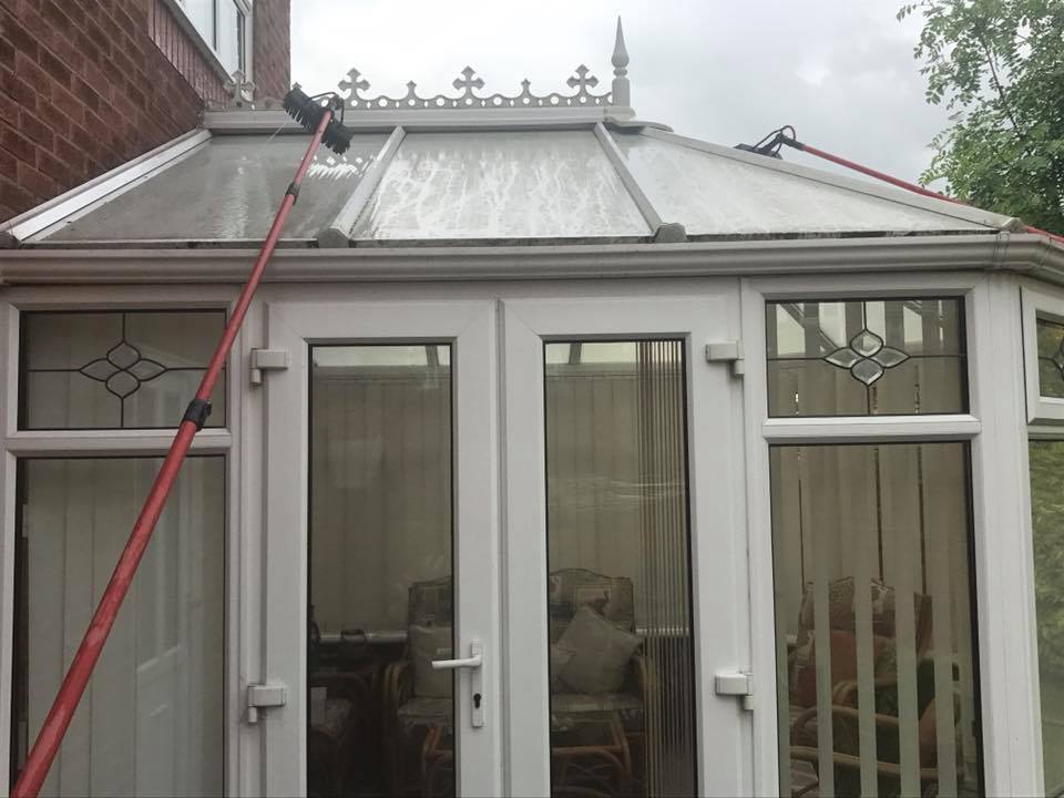 Image of brush cleaning the conservatory roof outside.