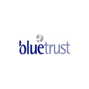 Blue Trust Logo is shown. Blue is a darker blue, and trust is a paler, pastel blue with purple undertones. There is a small ribbon in a circle on a grey background above the e.