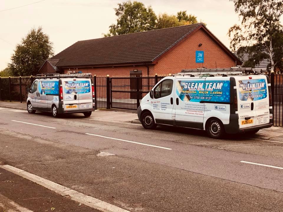 Image of two vans for The Gleam Team, parked up on the curb.